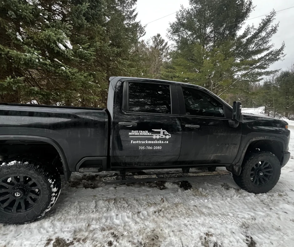 Fast Track Muskoka pickup truck with the company name and 705-706-2080 on the door, parked in the pines